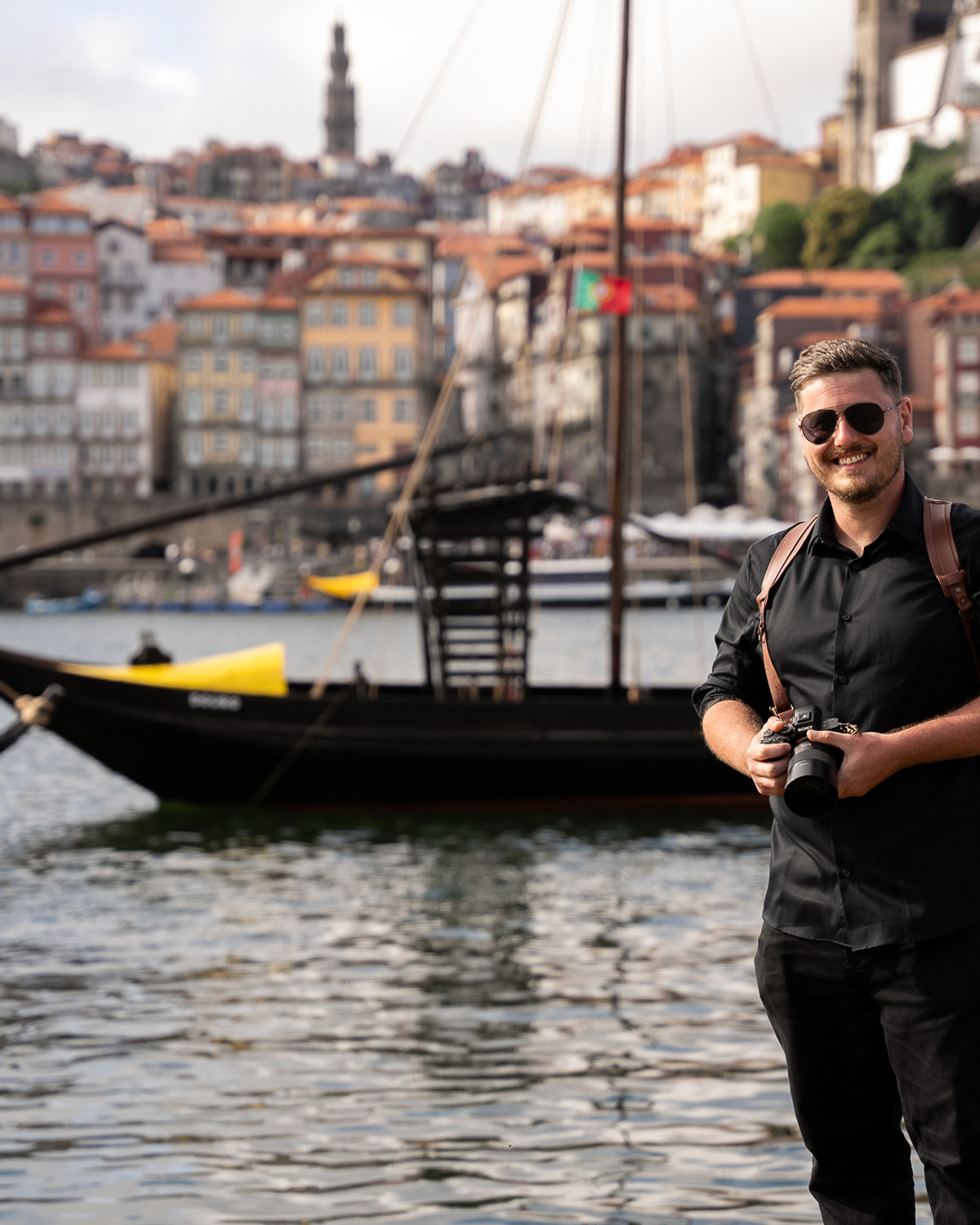 Kevin Joseph holding his camera on the Porto riverside